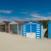Traditional beach huts on fine golden sand at West Wittering Beach West Sussex England UK