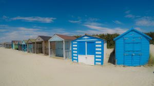 Traditional beach huts on fine golden sand at West Wittering Beach West Sussex England UK