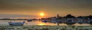 Summer sunset over Bosham Harbour and village with the church spire of Holy Trinity Church, West Sussex, UK